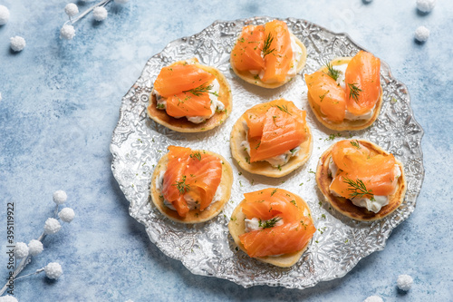 Blini with smoked salmon and sour cream, garnished with dill