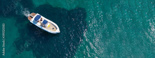 Aerial drone ultra wide panoramic photo of luxury inflatable rib cruising in low speed in tropical exotic bay with emerald sea