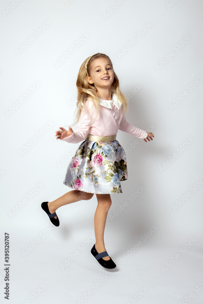 Beautiful little blonde girl dancing, jumping and having fun. White background. Beautiful little blonde girl dancing, jumping and having fun. White background.