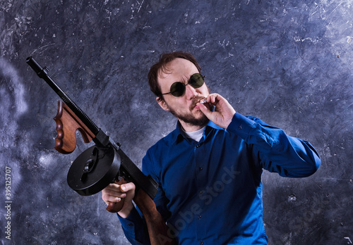 Mature man in sunglasses with tommy gun