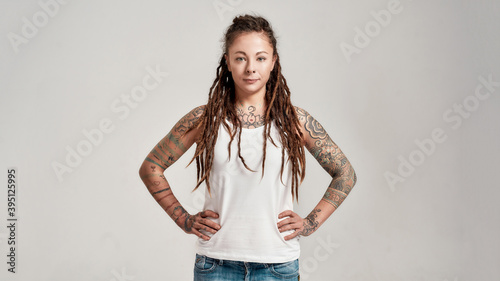 Φωτογραφία Portrait of young tattooed caucasian woman with dreadlocks wearing white shirt,