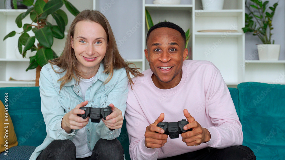 Happy interracial couple playing video games together at home Happy interracial couple playing video games together at home