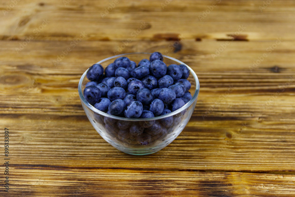 Fresh blueberry in glass bowl on a wooden table Fresh blueberry in glass bowl on a wooden table
