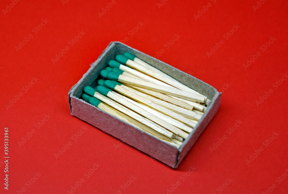 Wooden matches in cardboard box on red background Wooden matches in cardboard box on red background