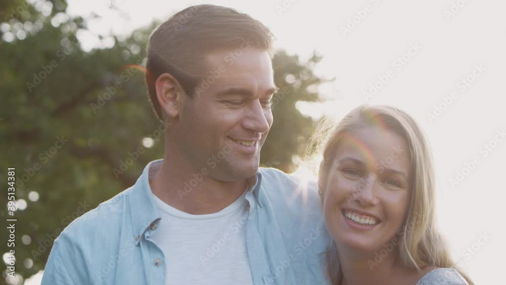 Portrait of loving couple in countryside hugging and kissing against flaring sun - shot in slow motion Portrait of loving couple in countryside hugging and kissing against flaring sun - shot in slow motion