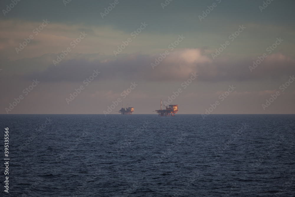 Oil platforms on the sea at dawn, Adriatic sea, Italy. Concept: extraction of fossil hydrocarbons, energy, pollution of the sea, global warming, oil company