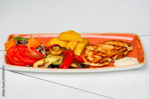 Grilled chicken with a side dishes of vegetables.