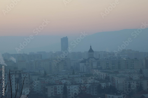 City on fog during sunset.