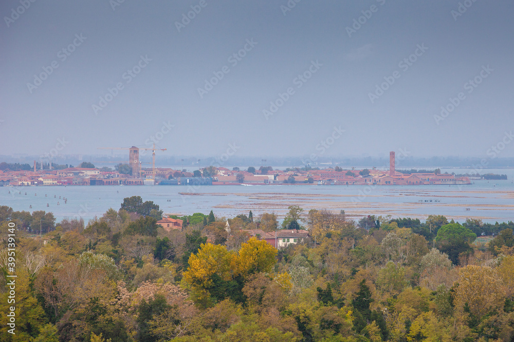 Autumn-colored trees and the Murano island in the background, Venice lagoon, Italy