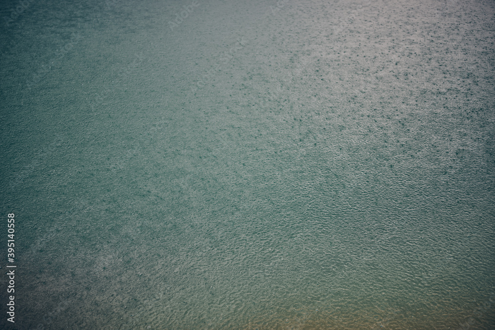 Rain falling into water. Rain falling into water.