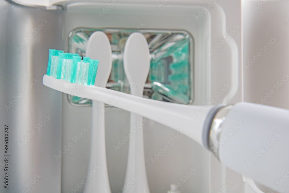 The bristles on the head of the sonic toothbrush. The electric toothbrush with replaceable attachments of tooth brush stored in a UV disinfection stand. The bristles on the head of the sonic toothbrush. The electric toothbrush with replaceable attachments of tooth brush stored in a UV disinfection stand.