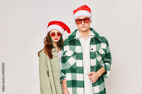 A man and a woman stand side by side in sunglasses Christmas holiday New Year hats friendship