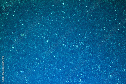 Frozen blue ice surface in winter, glare of snow crystals