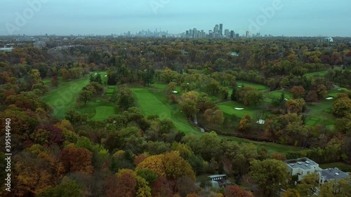 An aerial view tracks backwards over Toronto from the Rosedale golf course and a view of the Toronto skyline to prestigious houses in Hoggs Hollow.