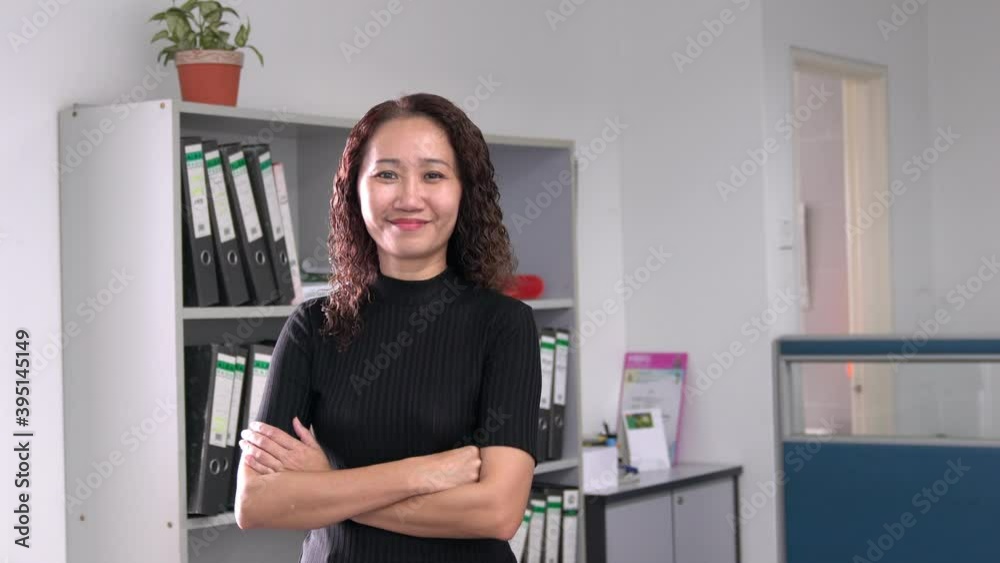 Portrait of an Asian businesswoman smiling, confident. Office setting. Portrait of an Asian businesswoman smiling, confident. Office setting.