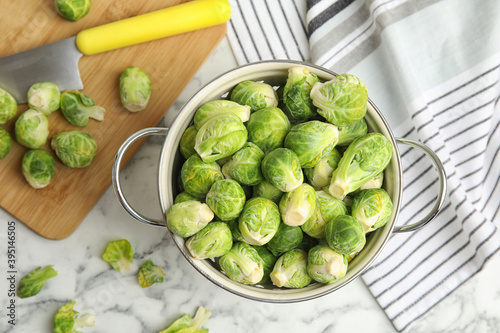 Fresh Brussels sprouts on white marble table, flat lay