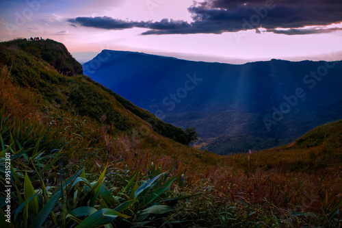 tourist on mountain top of phu tubberk thailand against beautiful sun light photo