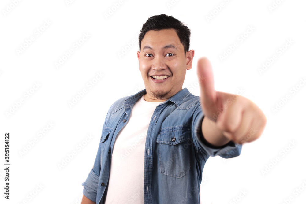 Portrait of young Asian man shows thumbs up sign, happy smiling person, OK deal Portrait of young Asian man shows thumbs up sign, happy smiling person, OK deal