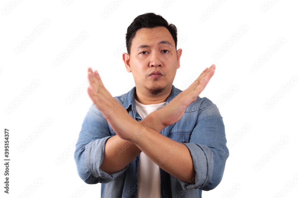 Young Asian man shows crossed arms gesture, giving warn to stop gesture, rejection Young Asian man shows crossed arms gesture, giving warn to stop gesture, rejection