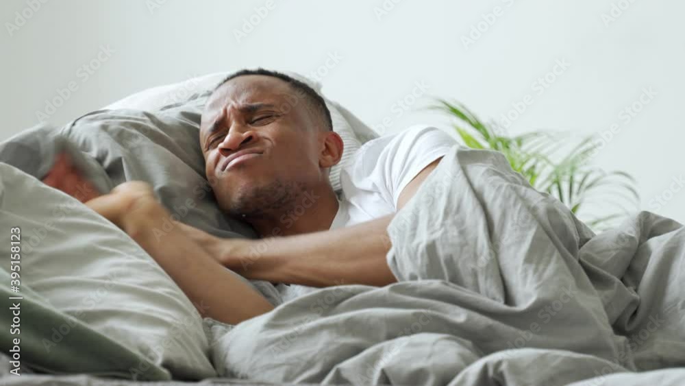 Young afro-american man meeting dawn in bed, suffering from insomnia Young afro-american man meeting dawn in bed, suffering from insomnia