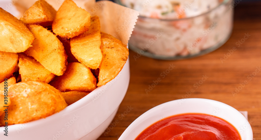 Tradition french fries from organic bio potato wedges with skin dip in ketchup Tradition french fries from organic bio potato wedges with skin dip in ketchup