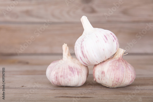 Three heads of fresh garlic on the wooden table