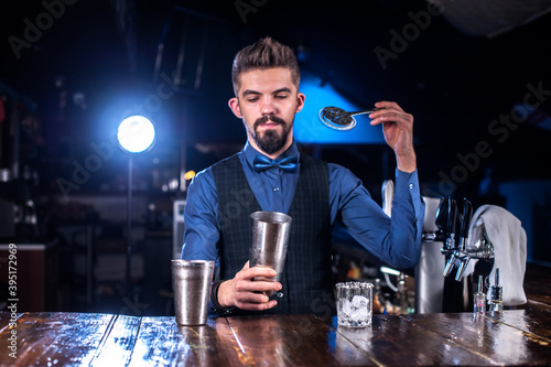 Bartender mixes a cocktail on the public house photo