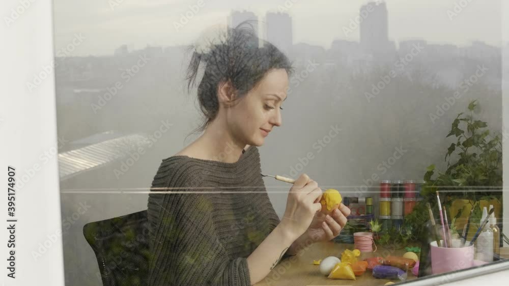 Woman molding colorful clay watching online learning lesson on the smartphone