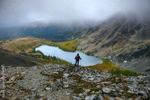 Hiker on cliff above the lake in stormy weather. Goat lake in  Cathedral Provincial Park. Keremeos. British Columbia. Canada  photo