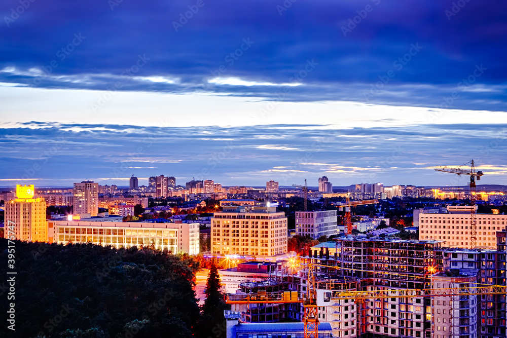 Minsk City at NIght with Construction Site and Building Cranes in Frame at Dusk.