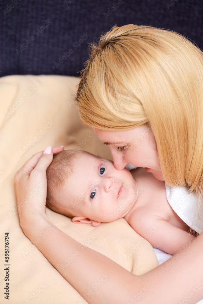 Portrait of Young Caucasian Mother Embracing Her Newborn Baby Boy Lying on Bed. Portrait of Young Caucasian Mother Embracing Her Newborn Baby Boy Lying on Bed.
