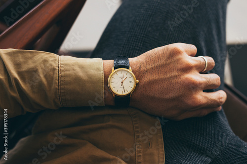 man fashionable wearing stylish looking at luxury watch on hand check the time at workplace.concept for managing time organization working,punctuality,appointment