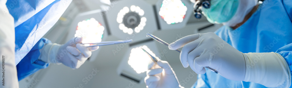 Close-up of gloved hands holding surgical equipment at the operating room, For Medical surgery banner Background