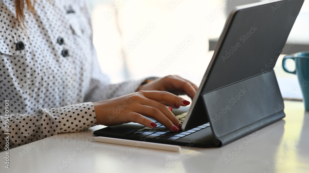 Cropped shot of woman using computer tablet searching information online at her work place. Cropped shot of woman using computer tablet searching information online at her work place.