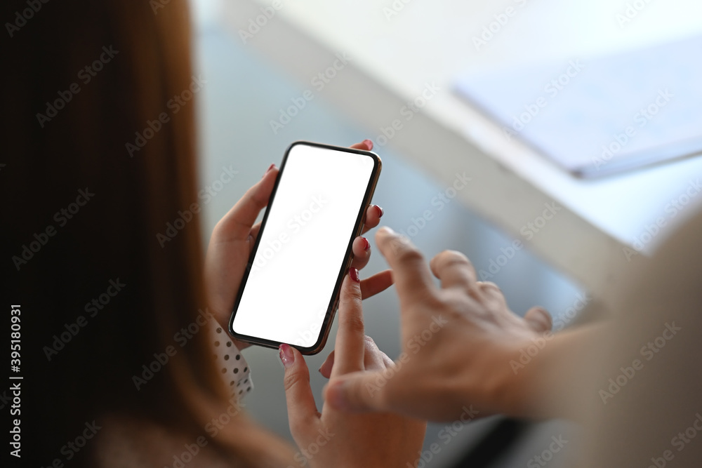Close up view of two female are reading information on cell mobile phone during in office setting. Close up view of two female are reading information on cell mobile phone during in office setting.