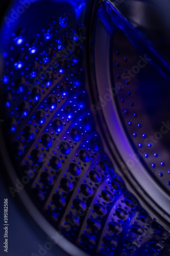 Washing machine drum illuminated by ultraviolet light