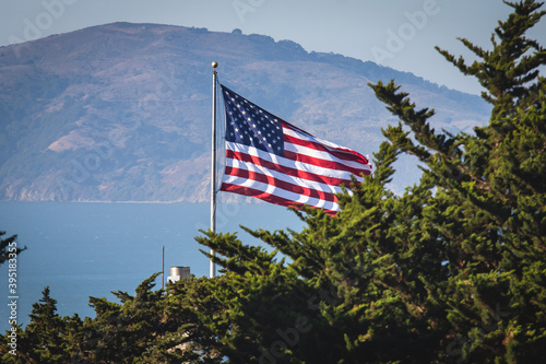 Photography View of waving American flag in the wind with beautiful blue sky in background,