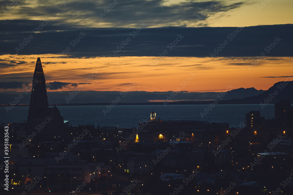 Beautiful night dusk view of Reykjavik, Iceland, aerial view with Hallgrimskirkja lutheran church, with scenery beyond the city, Esja mountain and Faxafloi bay