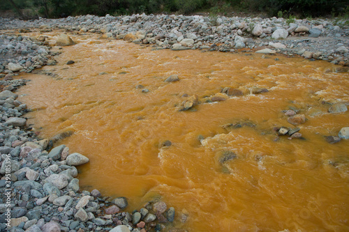 The environment. Water pollution and contamination. View of the yellow river carrying toxic waste. photo