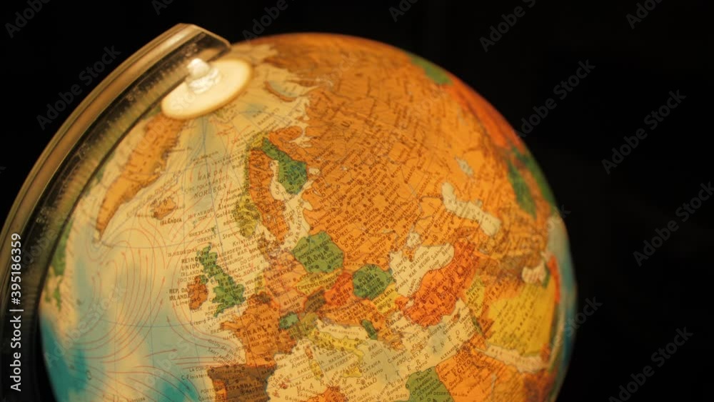 man spinning old vintage 80s globe to reach Europe 4k
