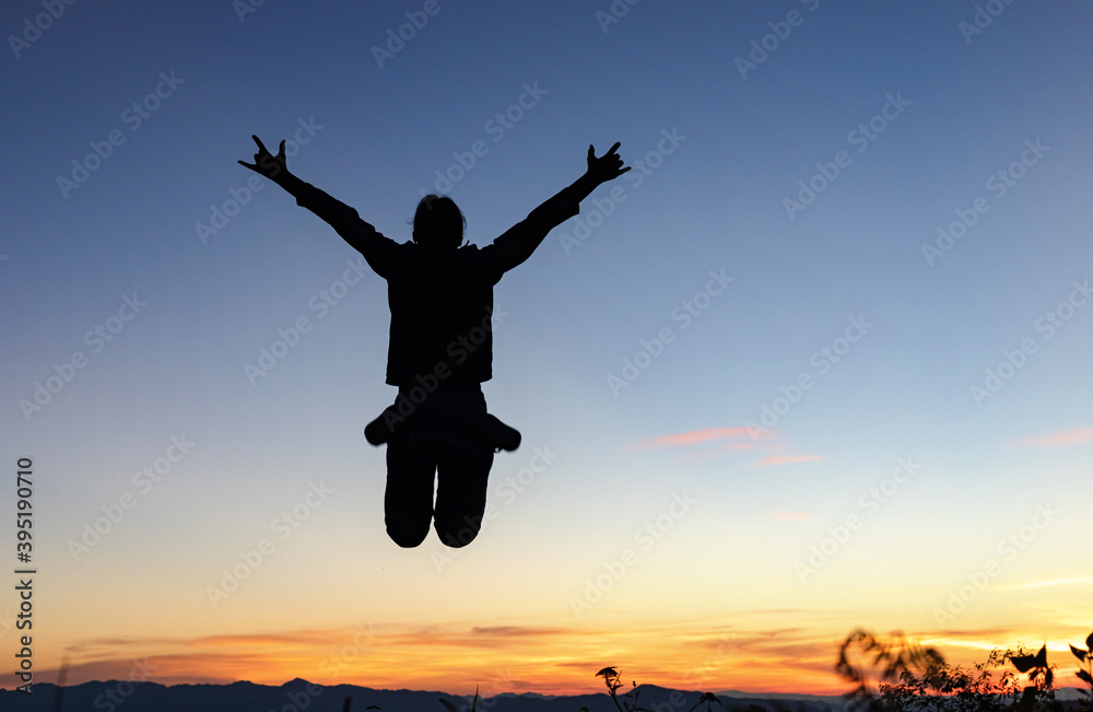 Silhouette of happy girl jumping playing on mountain at sunset Silhouette of happy girl jumping playing on mountain at sunset