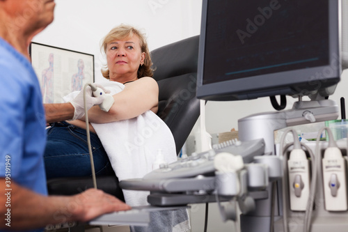 doctor examination a mature woman at abdomen with ultrasonography device