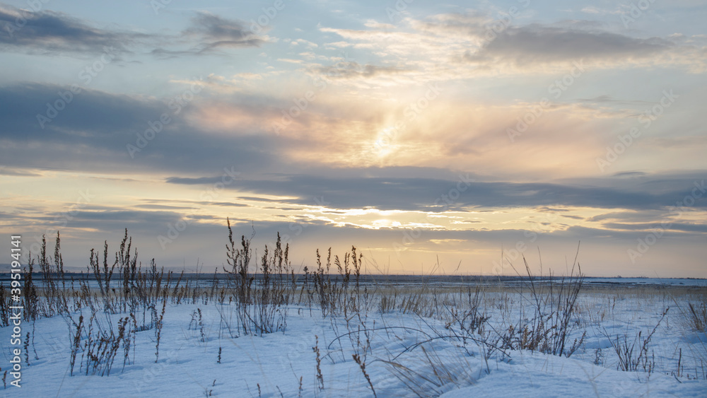 Winter landscape of a snow field with a sunset background. Natural background
