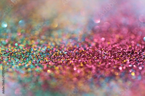 Multicolored glitter texture with shining bokeh.Wallpaper phone shining glitter.New Year and Christmas background.