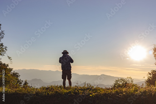 Happy man in sun hat enjoying the holidays on mountain sunset © AungMyo