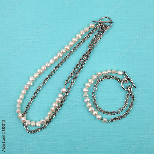 Luxury elegant baroque pearl necklace and bracelet on bright turquoise textured background