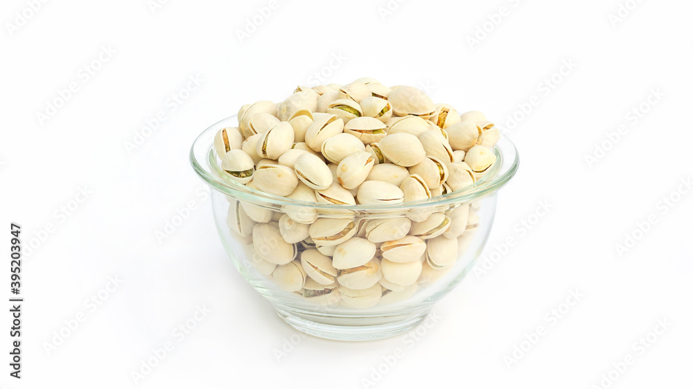 Pistachio nuts in a bowl on a white background. Pistachio nuts in a bowl on a white background.