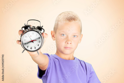 School boy showing alarm clock