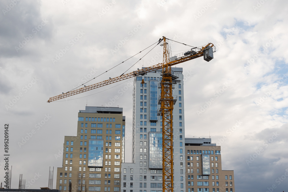 tower crane builds a high-rise house with a monolithic house against the background of skyscrapers of business centers