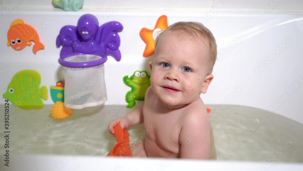 Child bathes in a baby bath, plays with toys Child bathes in a baby bath, plays with toys